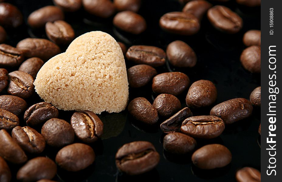 Sugar in shape as heart on coffe seed. Sugar in shape as heart on coffe seed