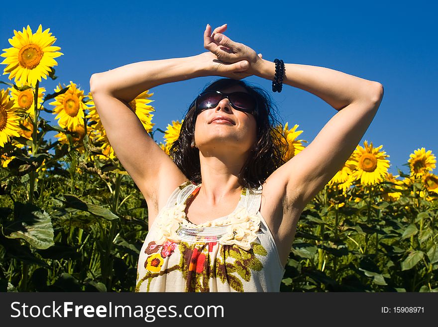 Young beautiful woman on field in summer