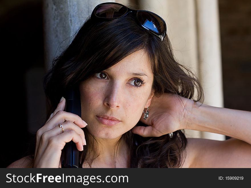 Beautiful woman talking on cell phone at street