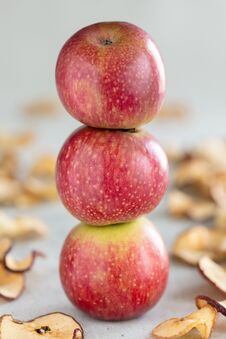 Stack Of Three Fresh Apples And Sun Dried Apple Chips As A Healthy Snack, Vertical Composition Royalty Free Stock Photos