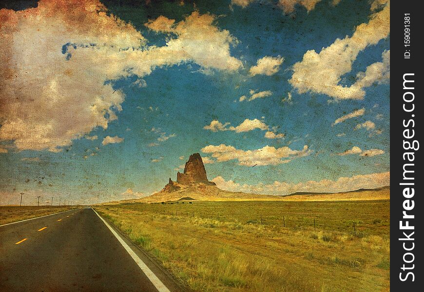 Agathla Peak is a peak south of Monument Valley, Arizona, USA, seen from U.S. Route 163. Made like a vintage canvas painting.