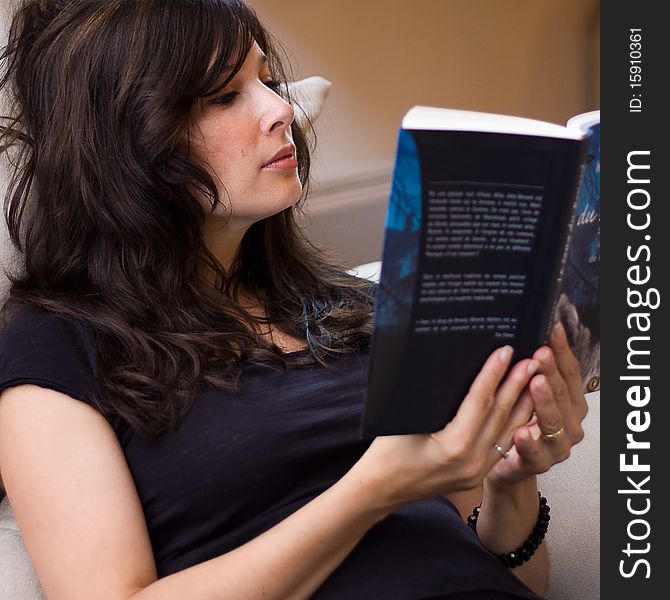 Beautiful woman reading a book on the couch