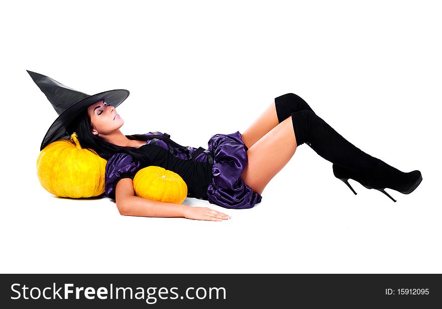 Pretty sleeping young brunette woman dressed as a fairy with pumpkins