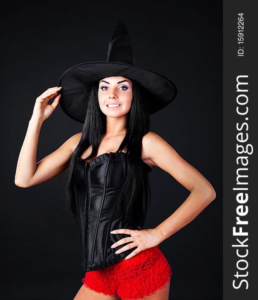 Studio portrait of a sexy young brunette woman dressed as a witch