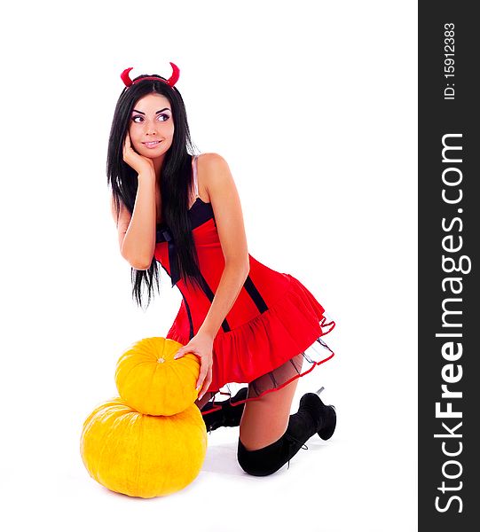 Sexy young brunette woman dressed as an imp with a pumpkin. Sexy young brunette woman dressed as an imp with a pumpkin