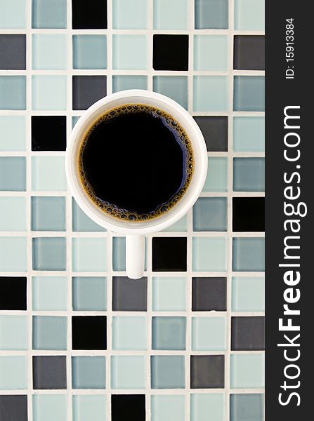 Black coffee in white cup on mosaic background. Black coffee in white cup on mosaic background
