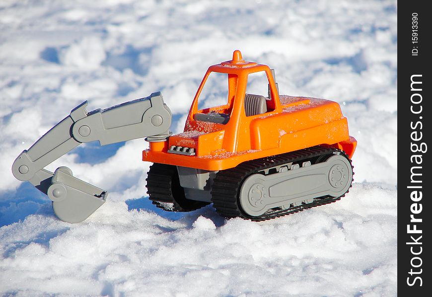 Little toy excavator in the snow