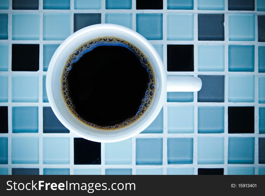 Black coffee in white cup on mosaic background. Black coffee in white cup on mosaic background