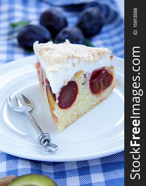 Plum cake on white plate with a fork and a napkin. Plum cake on white plate with a fork and a napkin