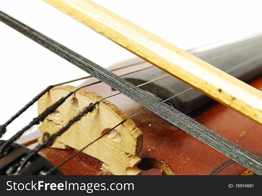 Violin with the bow on white background close-up of strings. Violin with the bow on white background close-up of strings