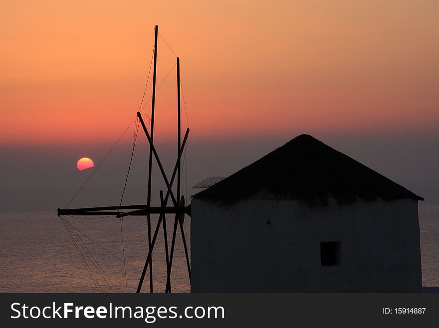 Sunset over the greece islands, view from greece islnad Santorini, belongs to Kyklades islands,Aegean sea. Very special orange sunset and beautiful nature, many original houses and windmills.