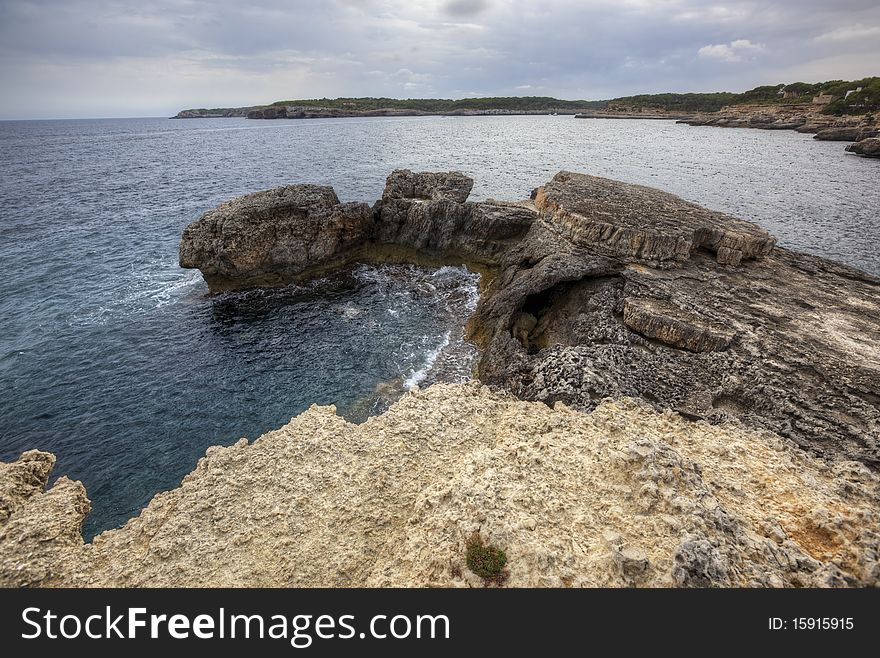 Wide gloomy landscape with dark sea and rock shore. Wide gloomy landscape with dark sea and rock shore