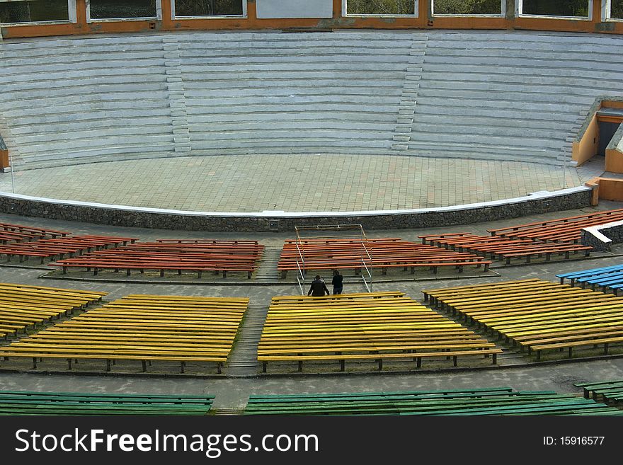 Empty outdoor theatre with rows of empty seats and stage