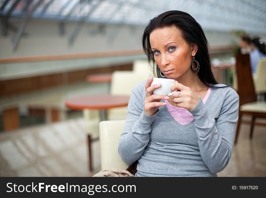 Beautiful young girl is drinking coffee in the shopping mall. Beautiful young girl is drinking coffee in the shopping mall