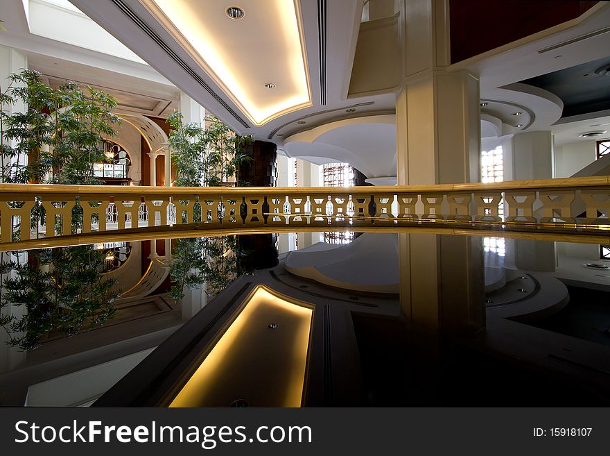 View of an atrium in a luxury hotel, with the ceiling reflected in the polished surface of a grand piano (bottom half of image). View of an atrium in a luxury hotel, with the ceiling reflected in the polished surface of a grand piano (bottom half of image)