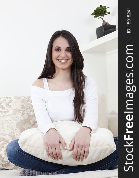 Beautiful brunette sitting on white sofa