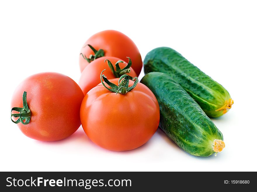 Red tomatoes and green cucumbers isolated on white background