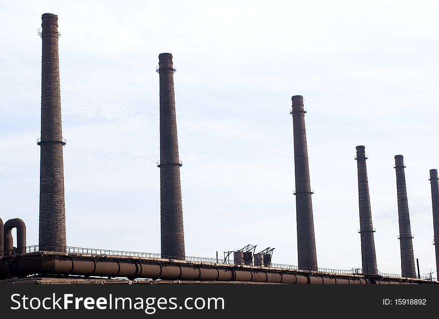 Smokestack and piping on the sky background. Smokestack and piping on the sky background