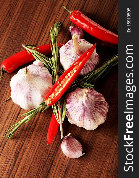 Fresh garlic with red pepper and rosemary on a table. Fresh garlic with red pepper and rosemary on a table.