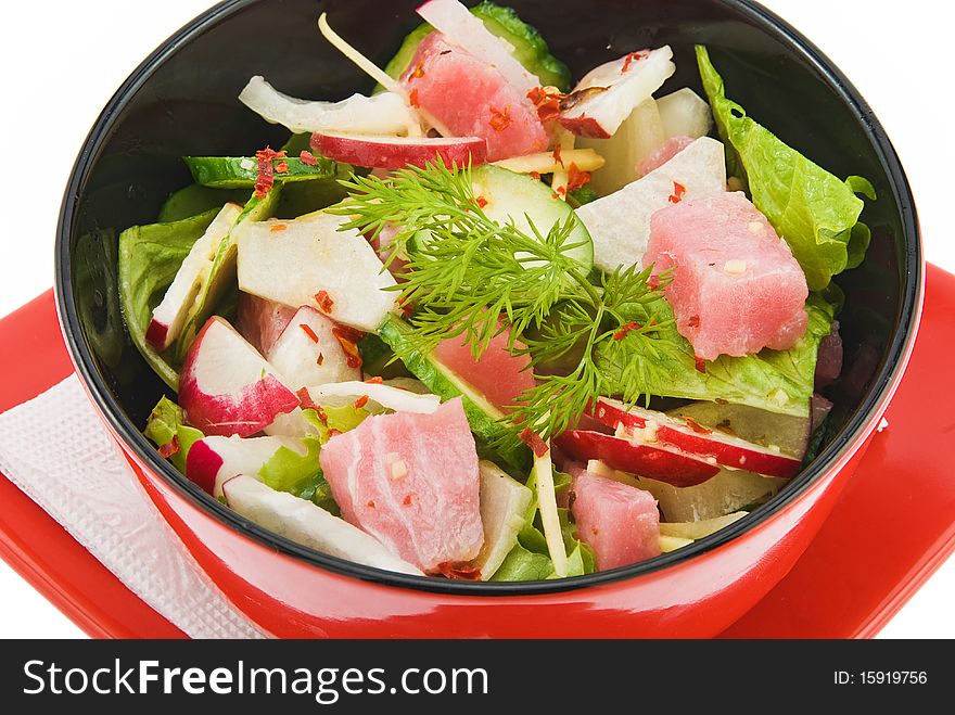 Salad with tunny on red plate isolated. Salad with tunny on red plate isolated