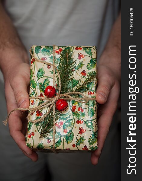 Wrapped New Year`s gifts with fir and cones and bells in hands. Life style