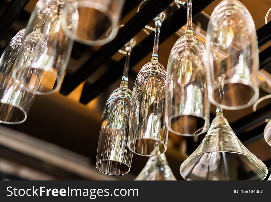 A lot of champagne glass hanging on a rack with blurred background