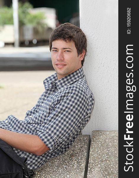 Young man sitting on the ground with mobile phone. Young man sitting on the ground with mobile phone