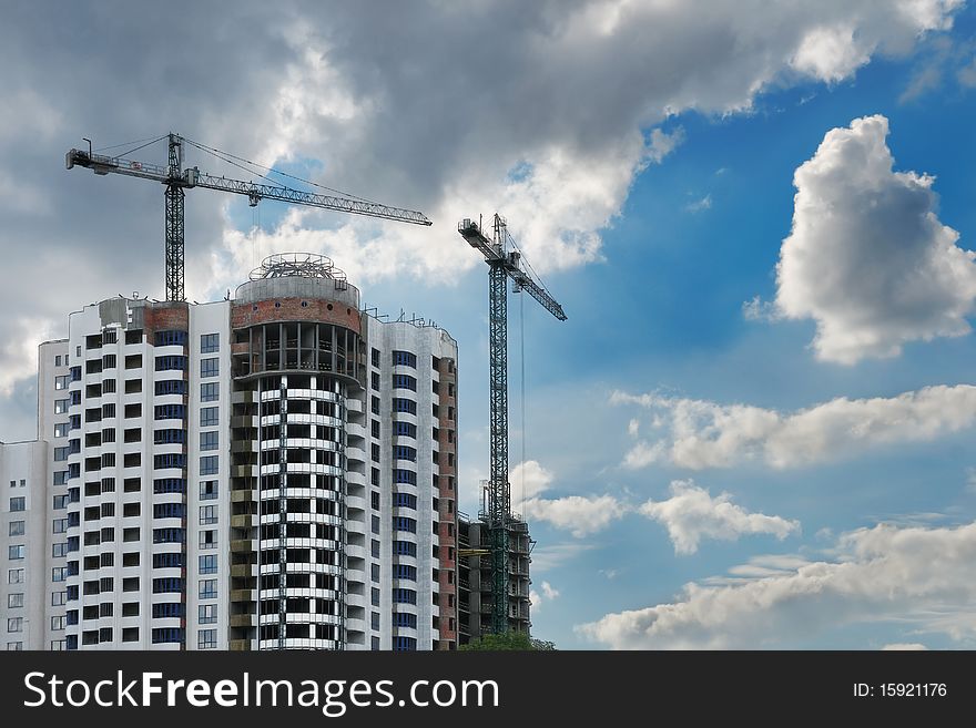 Construction site with cranes and unfinished residential house. Construction site with cranes and unfinished residential house