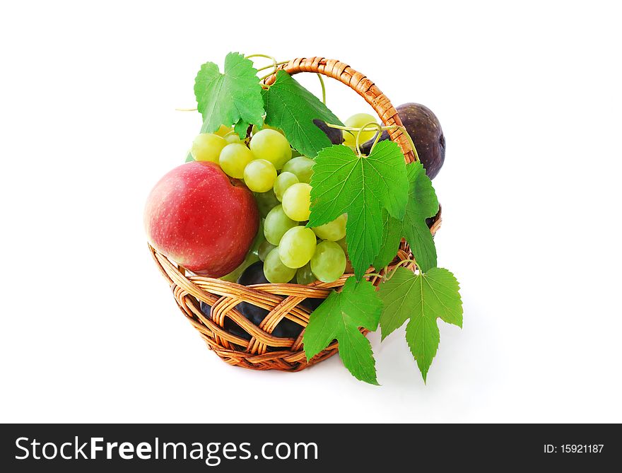 Basket with juicy grapes, apples, plums and figs isolated on white. Basket with juicy grapes, apples, plums and figs isolated on white