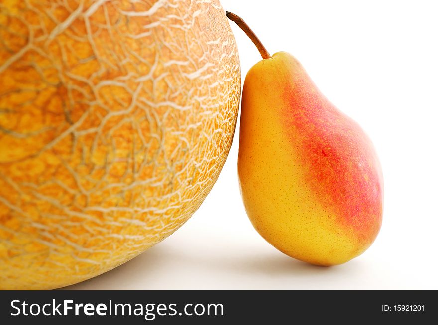 Artistic photo of a pear leaned against a melon isolated on white background with shadow. Artistic photo of a pear leaned against a melon isolated on white background with shadow