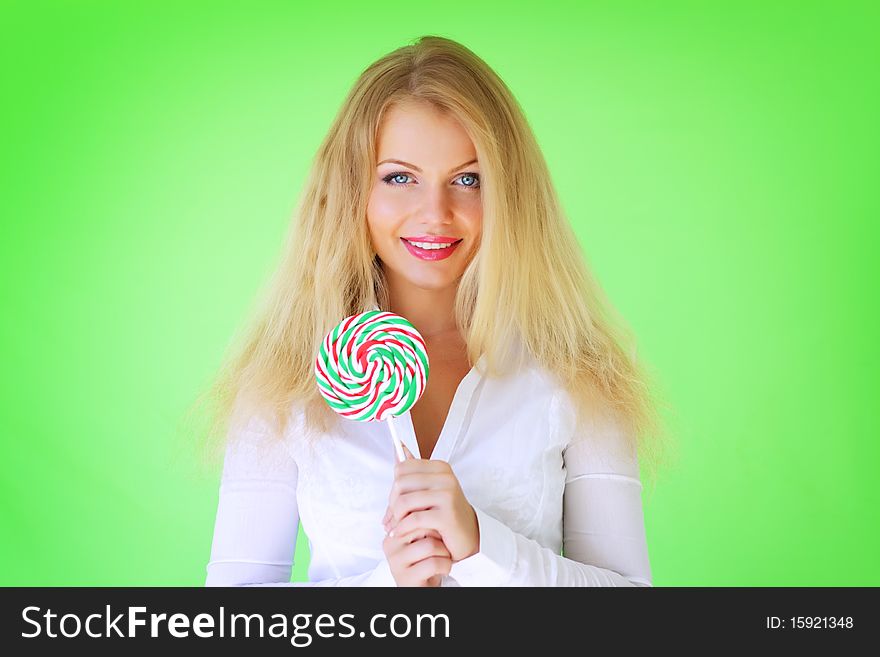Beautiful girl holding lollipop on a green background