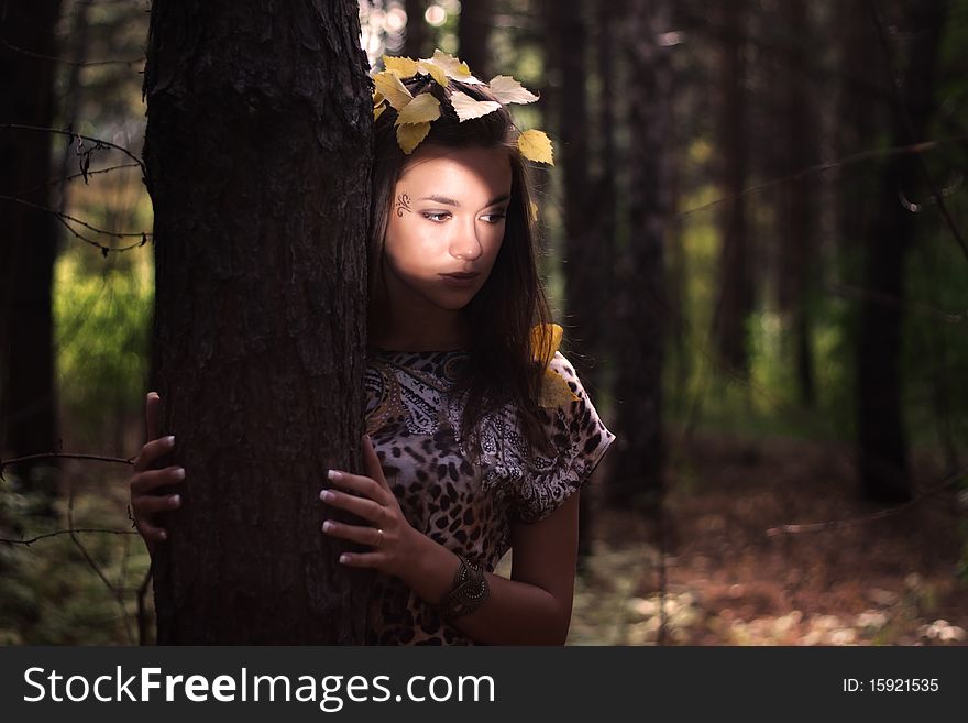 Dreamy girl standing next to a tree