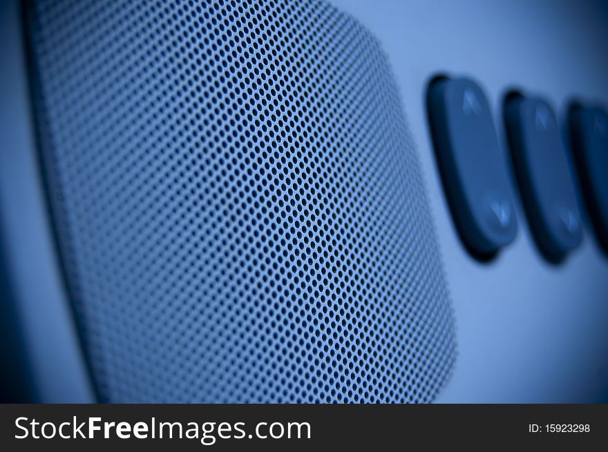 A blue loudspeaker with some key in background