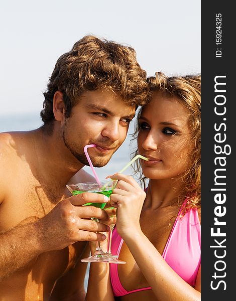 Young couple with cocktails on the seaside