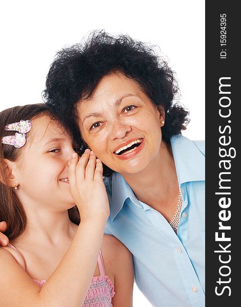 Close-up of a grandmother and her granddaughter whispering something fanny  into her ear. Close-up of a grandmother and her granddaughter whispering something fanny  into her ear.