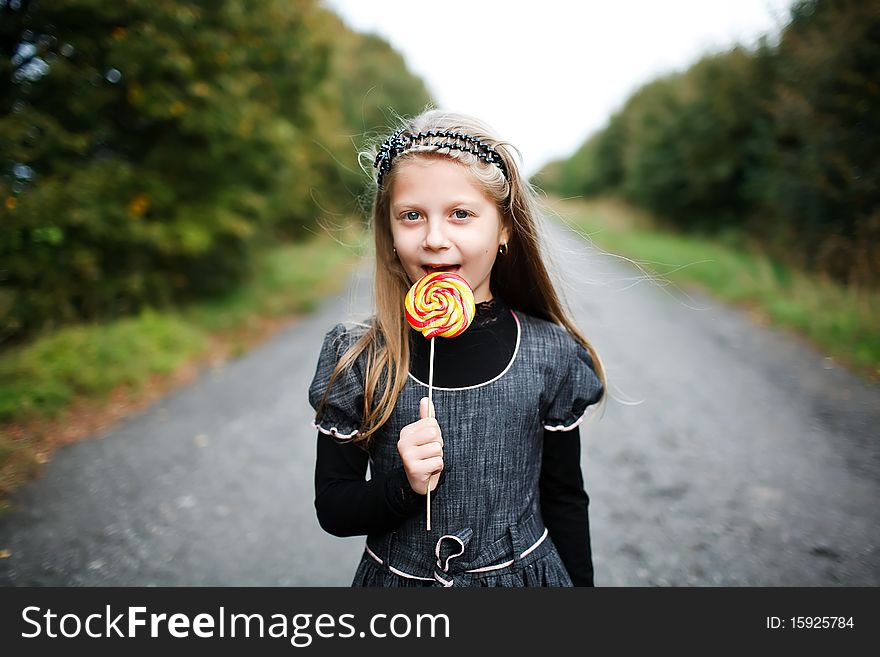 An image of little girl with candy in his hand