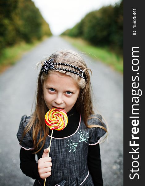 An image of little girl with candy in his hand