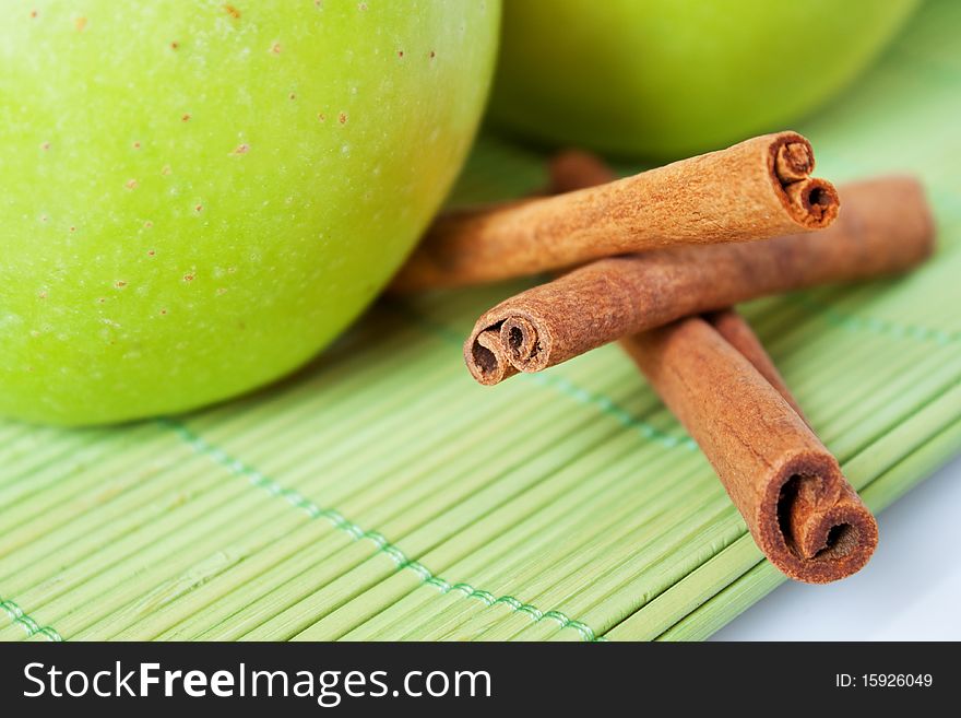 Green apples with cinnamon on a green tablecloth