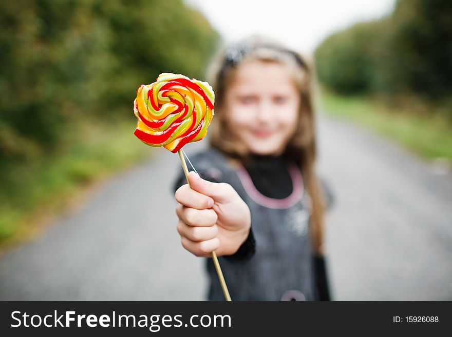 An image of little girl wit lollipop in his hand. An image of little girl wit lollipop in his hand