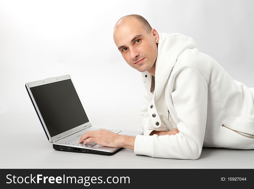 Portrait of a young man using a laptop, gray background