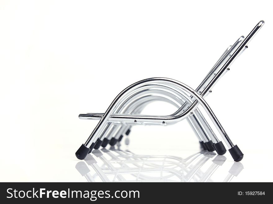 90-degree shot of a row of steel chairs in the white background