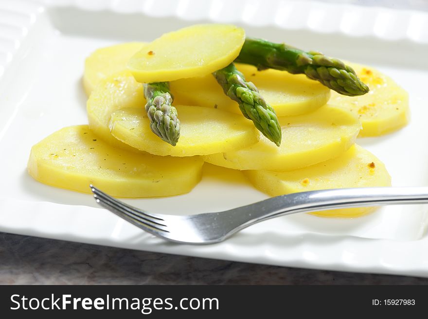 Still life of cooked potatoes with green asparagus