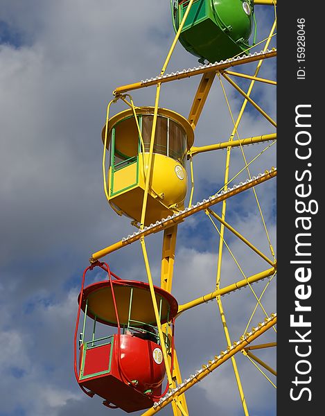 Attraction (Carousel) Ferris wheel on the background of the cloudy sky