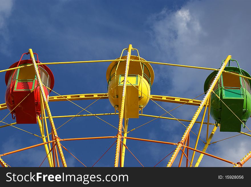 Attraction (Carousel) Ferris wheel on the background of the cloudy sky