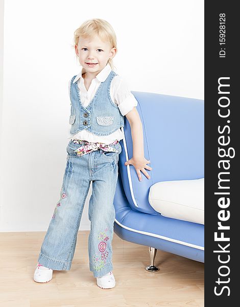 Little girl standing by sofa