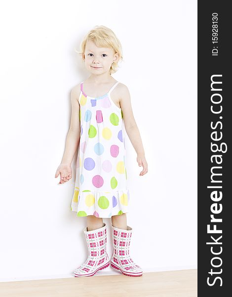 Little girl wearing dress and rubber boots