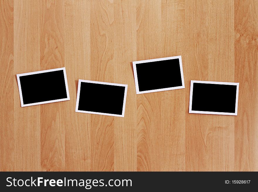 A row of blank photos stuck on a wooden wall. Clipping path included for the photos. A row of blank photos stuck on a wooden wall. Clipping path included for the photos.