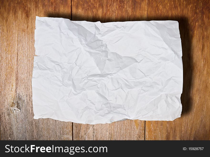 Crumpled paper on brown wood wall. Crumpled paper on brown wood wall