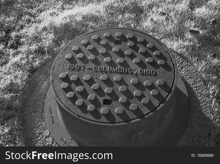 Manhole cover shot in infrared in a field