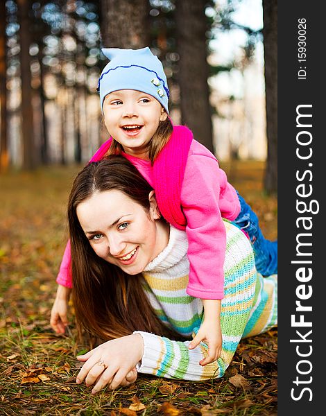 Young beautiful mother and her little daughter in the autumn park. Young beautiful mother and her little daughter in the autumn park